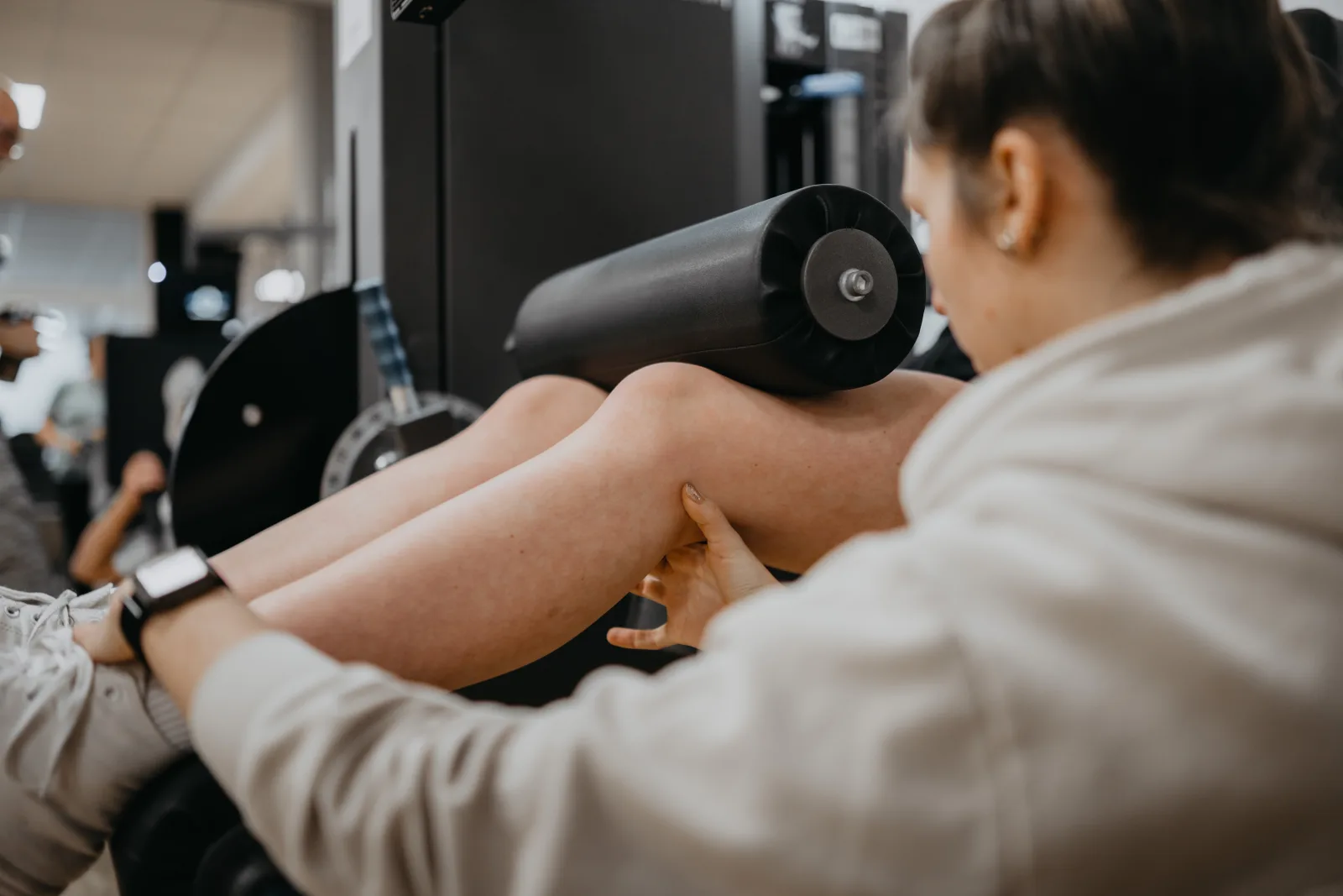 Begleitetes Training am Gerät, die Therapeutin korrigiert die Ausführung