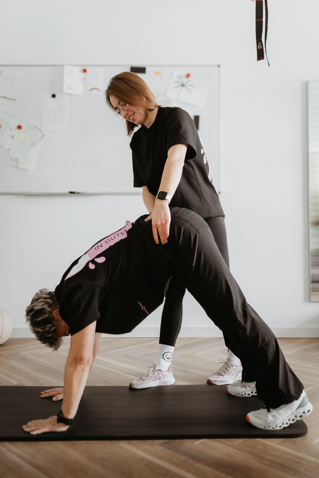 Therapeutin begleitet eine Dehnübung am Boden bei Physio Family Koblenz